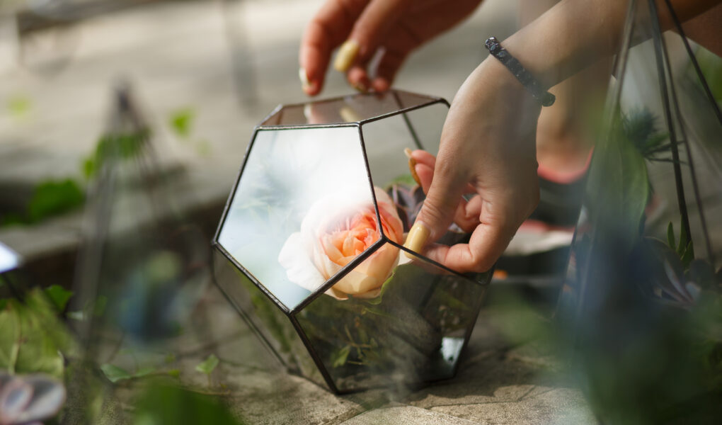 Florarium mit frischen saftigen Blumen. Eventdekoration mit frischen Blumen. Floristen-Workflow. Hochzeitsbankett-Design.